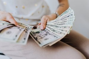 Woman holding a pile of US dollar notes